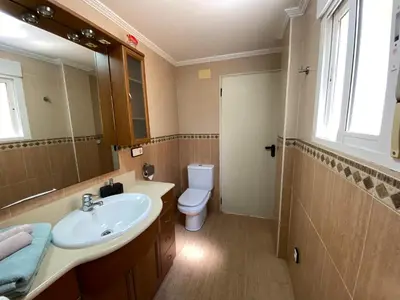 a bathroom with a sink and a toilet and a mirror at Guesthouse in Torrent in Valencia