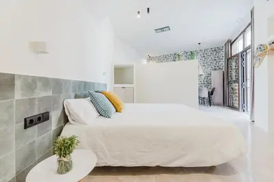 a bedroom with a large bed and a table at Loft Viñas in Valencia