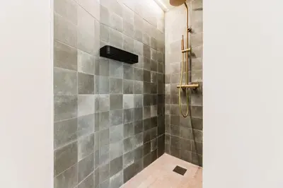 a bathroom with a shower with gray tiles at Loft Viñas in Valencia