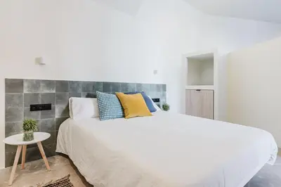 a bedroom with a large bed and a small table at Loft Viñas in Valencia