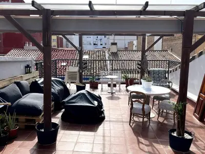 a patio with tables and chairs on a roof at Duplex Loft And Home Office 140m2 plus a 70m2 Terrace in Valencia