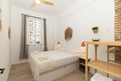 a small bedroom with a bed and a window at Illetes Flats -Apartamento con mucho encanto in Valencia