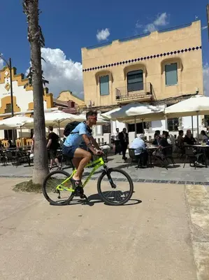 a man riding a bike down a street at Apartamento playa Veramar patacona in Valencia