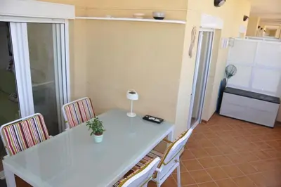 a kitchen with a white table and chairs and a refrigerator at Apartamento en la Playa de Canet de Berenguer in Canet de Berenguer