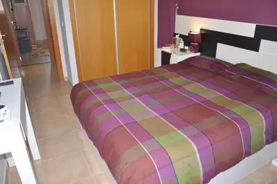 a bedroom with a large bed with a colorful comforter at Apartamento en la Playa de Canet de Berenguer in Canet de Berenguer