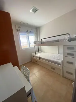 a small room with a bunk bed and a desk at Apartamento en la Playa de Canet de Berenguer in Canet de Berenguer