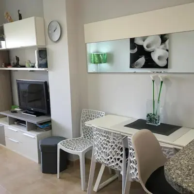 a living room with a table and chairs and a tv at Apartamento en la Playa de Canet de Berenguer in Canet de Berenguer
