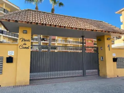 a building with a gate with a sign on it at Apartamento en la Playa de Canet de Berenguer in Canet de Berenguer