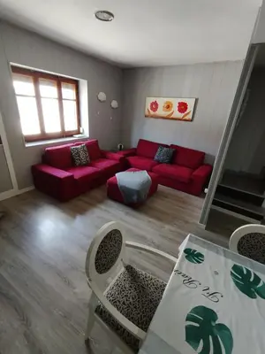a living room with a red couch and a table at rural relax Valencia in Villar del Arzobispo