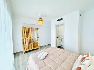 a bedroom with a bed with two towels on it at NUEVO, a 90 metros de la playa y con vistas al mar in Cullera