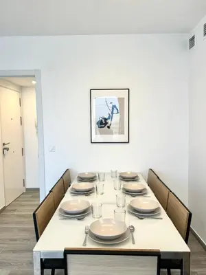 a dining room with a white table and chairs at NUEVO, a 90 metros de la playa y con vistas al mar in Cullera