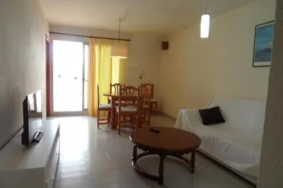 a living room with a couch and a table at Voramar Serviplaya Solo Familias in Casas Las Basas