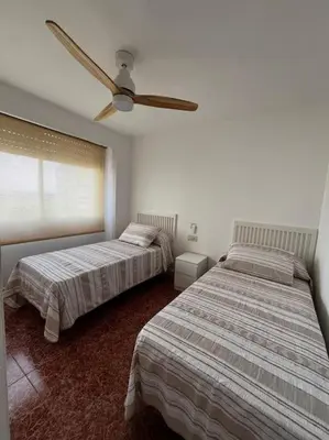 a bedroom with two beds and a ceiling fan at Tu Refugio con Vistas al Mar in Puebla de Farnals