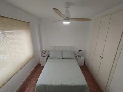 a bedroom with a bed and a ceiling fan at Tu Refugio con Vistas al Mar in Puebla de Farnals