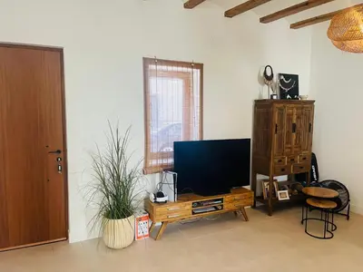 a living room with a flat screen tv on a wooden stand at Ca Erika in Aldaia
