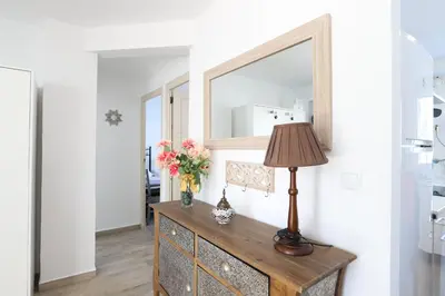 a mirror and a lamp on a dresser in a room at 2 apartamentos en una excelente villa de playa compartiendo Piscina y Jardín in Sagunto