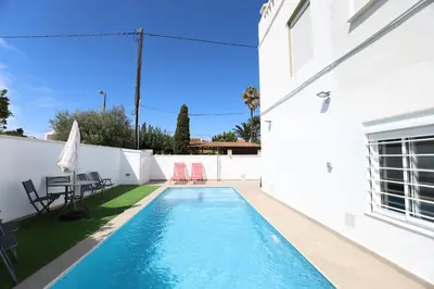 a swimming pool in the backyard of a house at 2 apartamentos en una excelente villa de playa compartiendo Piscina y Jardín in Sagunto