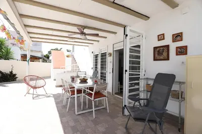 a dining room with a table and chairs on a patio at 2 apartamentos en una excelente villa de playa compartiendo Piscina y Jardín in Sagunto