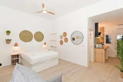 a white living room with a white couch and a ceiling fan at Illetes Flats - Loft encantador cerca de Bioparc in Valencia