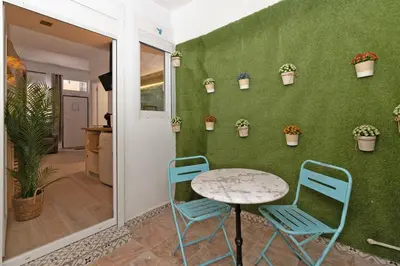 a table and two chairs next to a wall with plants at Illetes Flats - Loft encantador cerca de Bioparc in Valencia