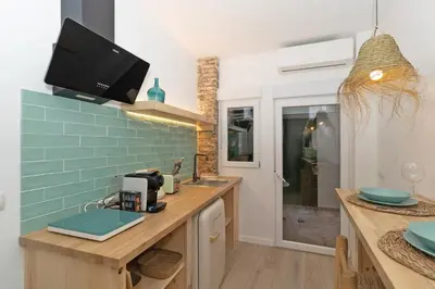 a kitchen with a sink and a tv on the wall at Illetes Flats - Loft encantador cerca de Bioparc in Valencia