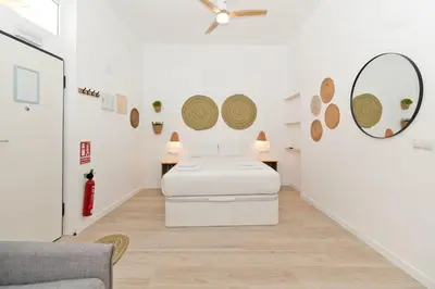 a white room with two beds and a couch at Illetes Flats - Loft encantador cerca de Bioparc in Valencia