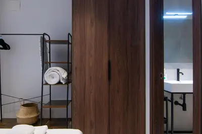 a bathroom with a wooden door and a sink at VLC HOST - Luz Casanova in Valencia