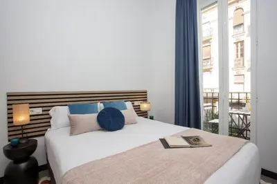a bedroom with a large white bed with a window at SingularStays Ca Iconic Living in Valencia