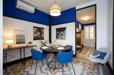 a dining room with a table and blue chairs at SingularStays Ca Iconic Living in Valencia