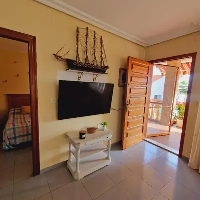 a living room with a tv and a small table at Chalet Playa Chilches in Chilches