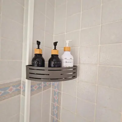 a shelf in a bathroom with four bottles on it at Chalet Playa Chilches in Chilches