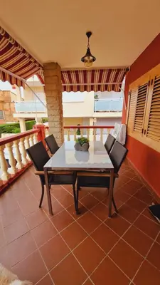 a patio with a table and chairs on a balcony at Chalet Playa Chilches in Chilches