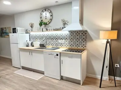 a kitchen with a stove and a clock on the wall at Arquitecto D in Valencia
