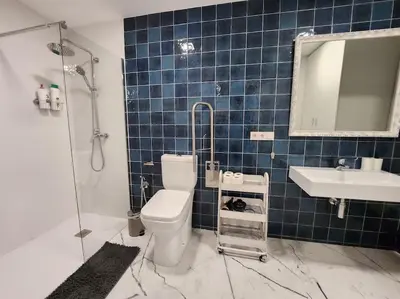 a blue tiled bathroom with a toilet and a sink at Arquitecto I in Valencia