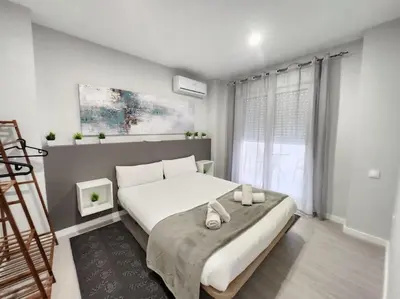 a bedroom with a large white bed and a window at Arquitecto I in Valencia