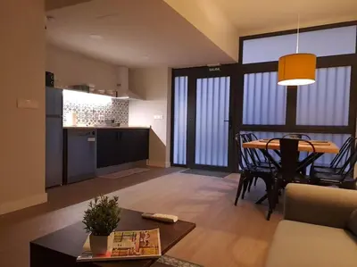a living room with a table and a kitchen at Explore Valencia! Tirant, city of science & Ruzafa in Valencia