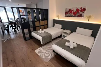 a hotel room with two beds and a dining room at Las Artes y las Ciencias I in Valencia