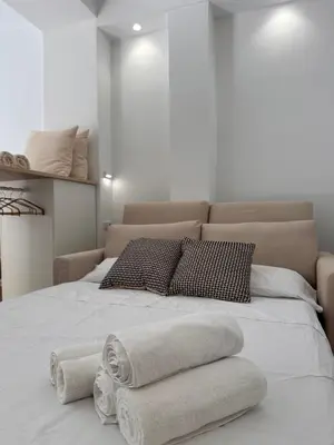 a white bed with towels on top of it at Apartamento mediterráneo in Valencia