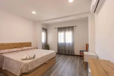 a bedroom with a large bed and a table at Casa rural las golondrinas in Quesa
