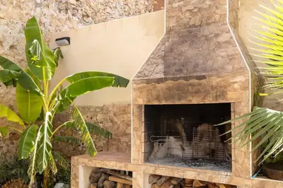 a stone fireplace in a room with plants at Casa rural las golondrinas in Quesa