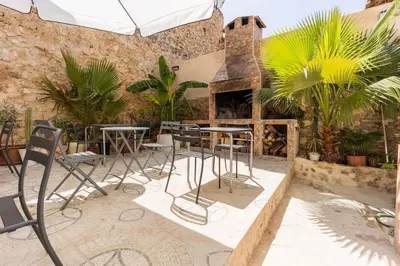 a patio with tables and chairs and a fireplace at Casa rural las golondrinas in Quesa