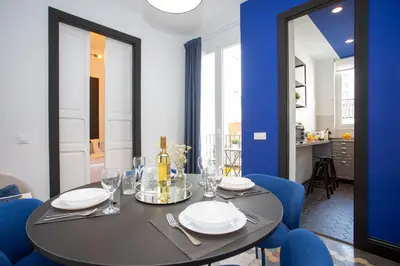 a dining room with a black table and blue chairs at SingularStays Ca Iconic in Valencia