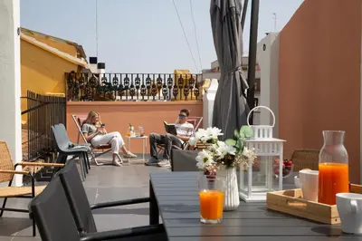 a group of people sitting on a patio with their laptops at SingularStays Ca Iconic in Valencia