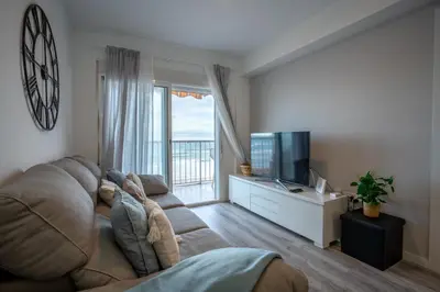 a living room with a large couch and a television at 1ª Linea de Mar 4pax Valencia 15 min in El Perellonet