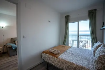a bedroom with a bed with a view of the ocean at 1ª Linea de Mar 4pax Valencia 15 min in El Perellonet