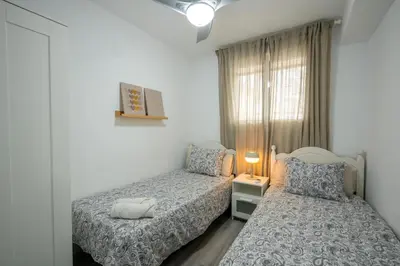 a bedroom with two beds and a window at 1ª Linea de Mar 4pax Valencia 15 min in El Perellonet