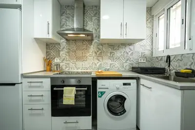 a white kitchen with a washing machine in it at 1ª Linea de Mar 4pax Valencia 15 min in El Perellonet