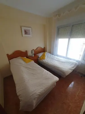a bedroom with two beds and a window at Cosy apartment near the beach in Cullera