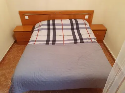 a bed with a striped pillow on top of it at Cosy apartment near the beach in Cullera
