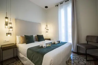 a bedroom with a large bed with two candles on it at MD Jorda Roig Arena in Valencia